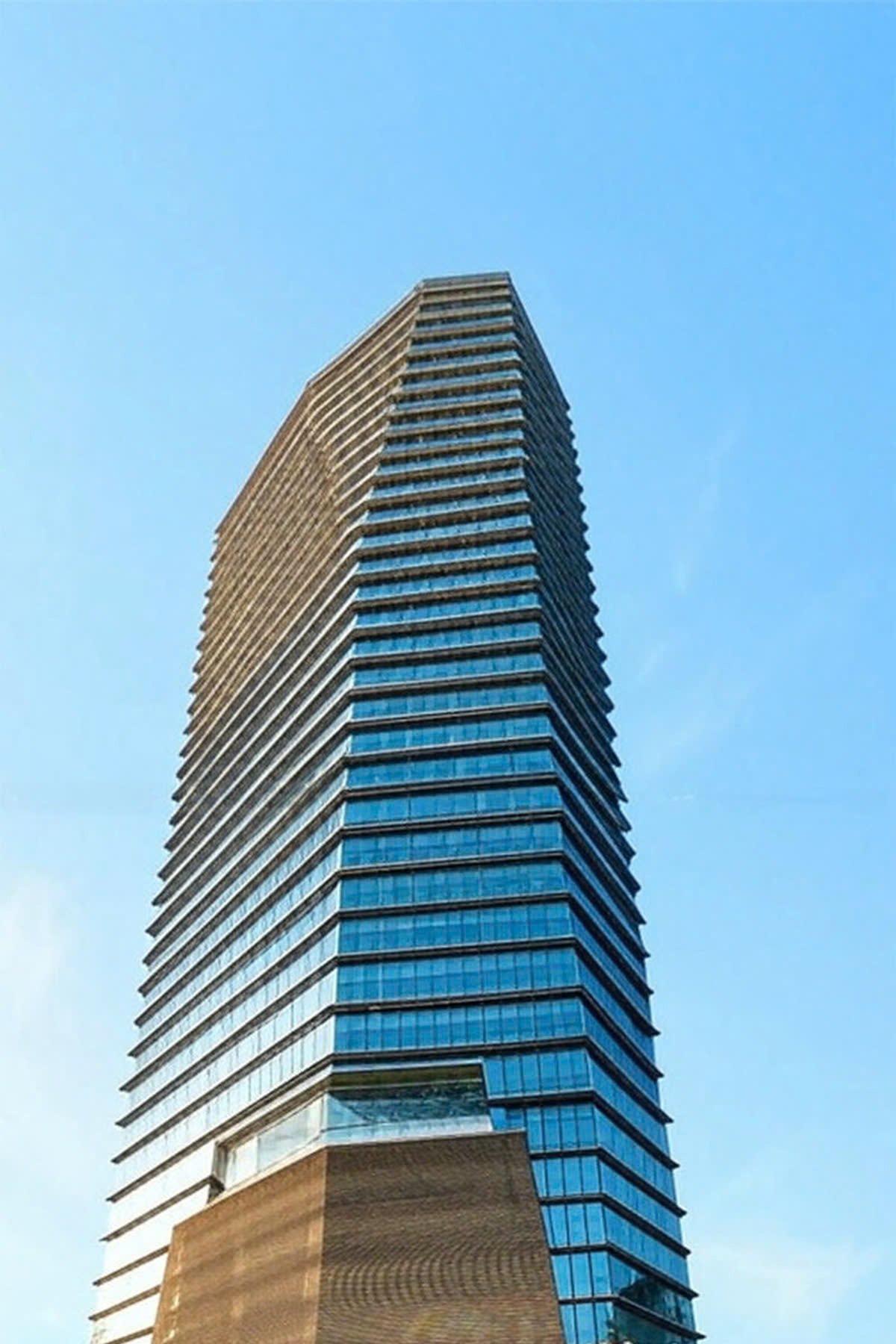 Tall Capital Building with glass facade and green promotional banners at entrance